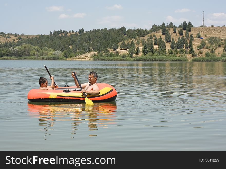 Father and son in the boat on lake