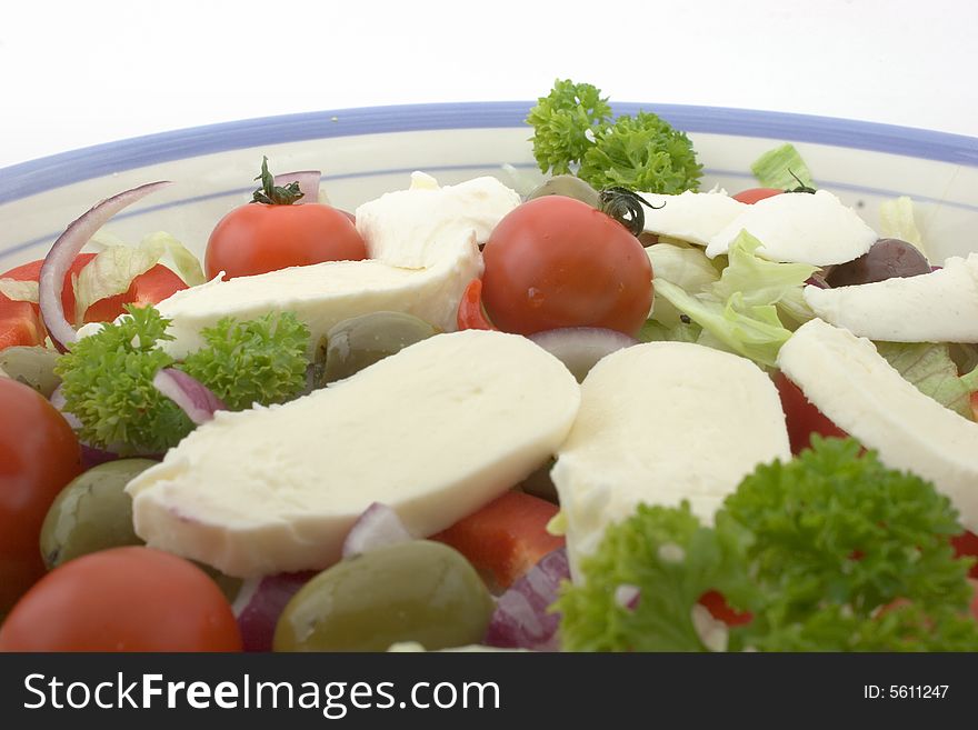 Mozzarella salad in a bowl, against a white background. Mozzarella salad in a bowl, against a white background