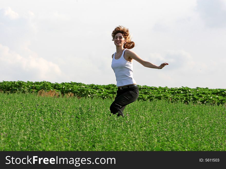 A beautiful girl jumping on the field