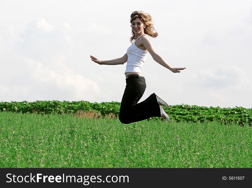 A beautiful girl jumping on the field