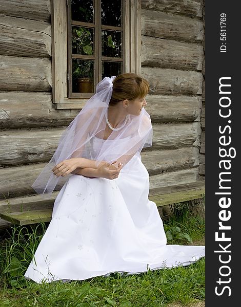 Beautiful bride sits on a bench