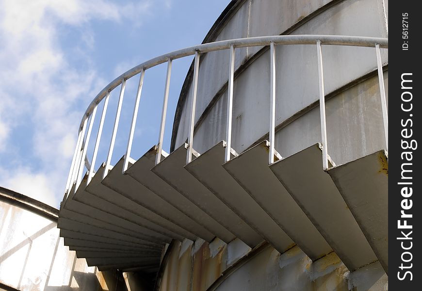 Spiral staircase up a industrial cylindrical tank to access its roof. Spiral staircase up a industrial cylindrical tank to access its roof