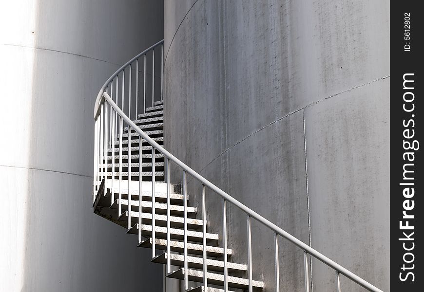 Spiral staircase up a industrial cylindrical tank to access its roof. Spiral staircase up a industrial cylindrical tank to access its roof