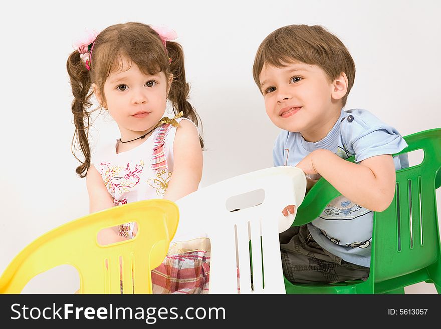 Adorable Children Sitting On Colorful Chairs