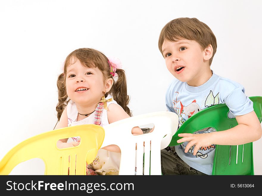 Adorable Children Sitting On Colorful Chairs