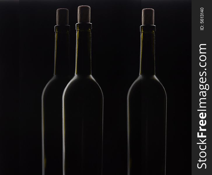 Three bottles of wine with a fuse on a black background