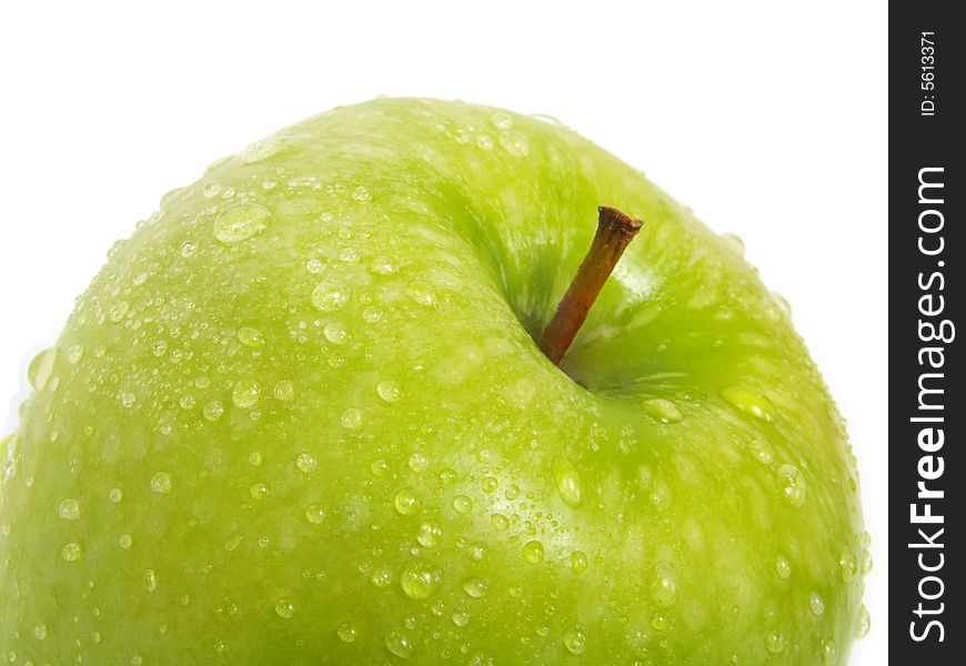 A closeup of a single fresh ripe green apple with water drops and isolated on white background. A closeup of a single fresh ripe green apple with water drops and isolated on white background