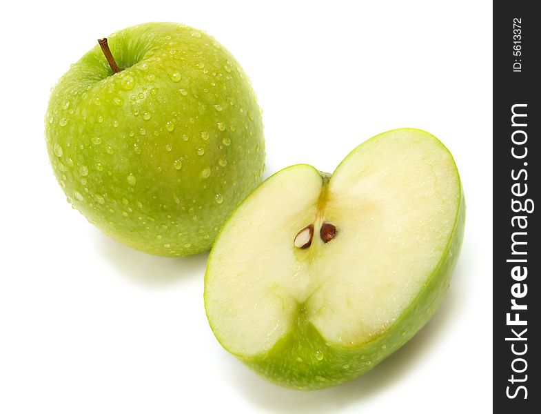 A half and a whole fresh ripe green apple with water drops isolated on white background. A half and a whole fresh ripe green apple with water drops isolated on white background