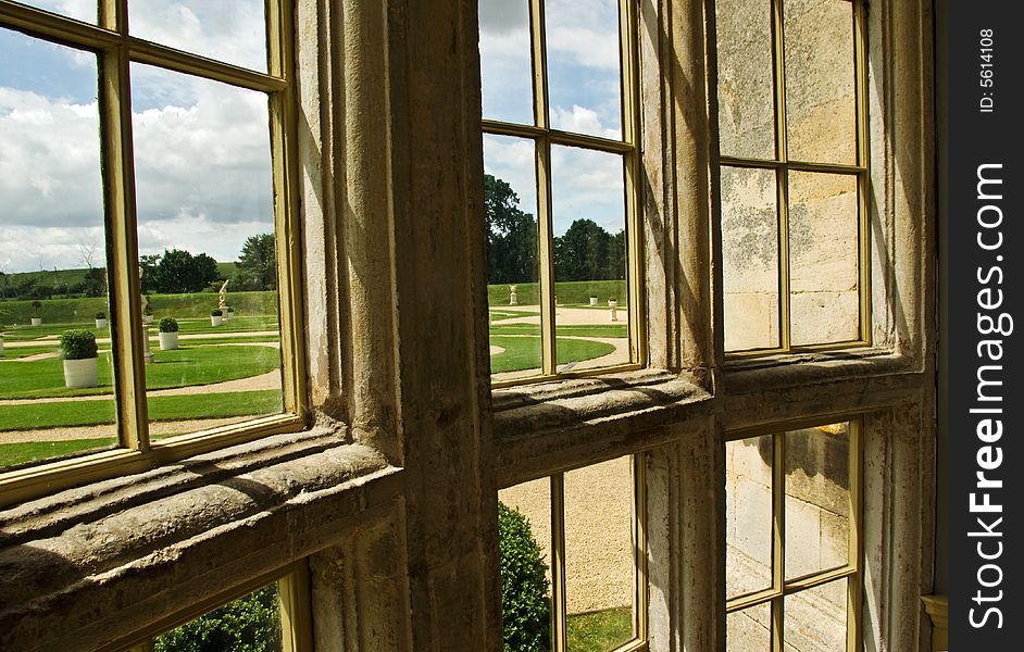 A view of a formal garden from a mansion window. A view of a formal garden from a mansion window.