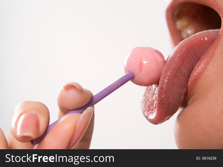 Young beautiful girl with lollipop in her mouth