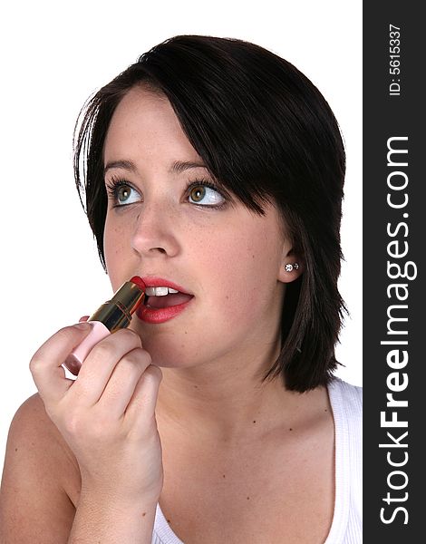 Beautiful teen applying lipstick on a high key background