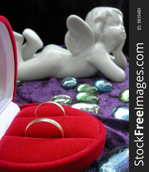 Wedding rings in red box with an angel