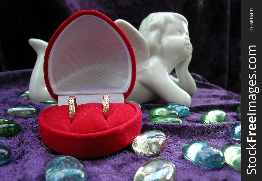 Wedding rings in red box with an angel