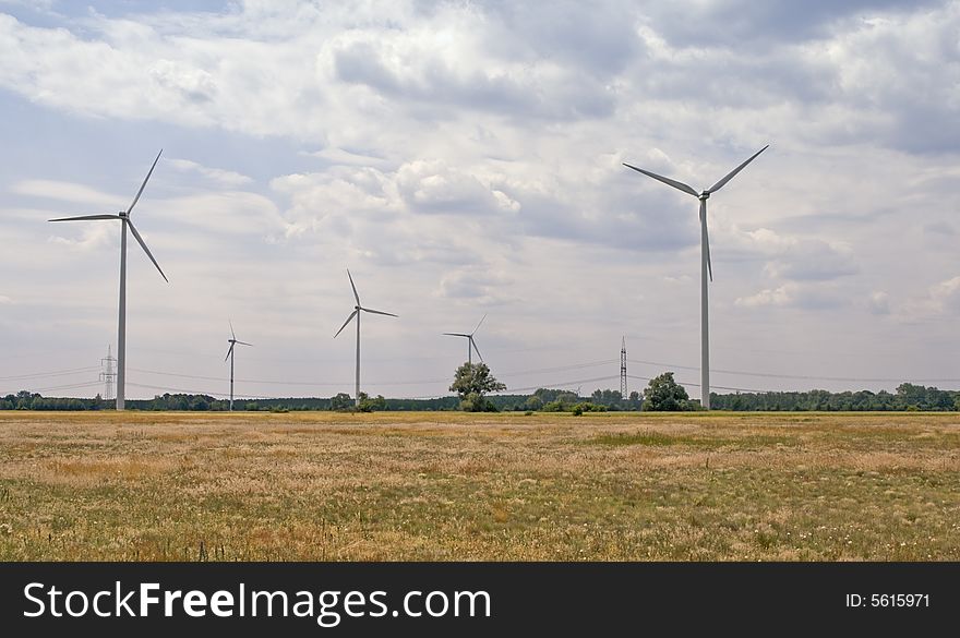 A field with eolian turbines in a cloudy day. A field with eolian turbines in a cloudy day.