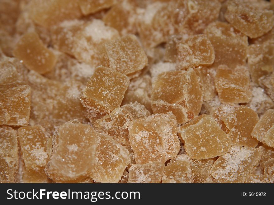 Pieces of crystallized ginger covered in sugar. Pieces of crystallized ginger covered in sugar