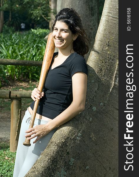 Woman Leaning Against Tree With Baseball Bat