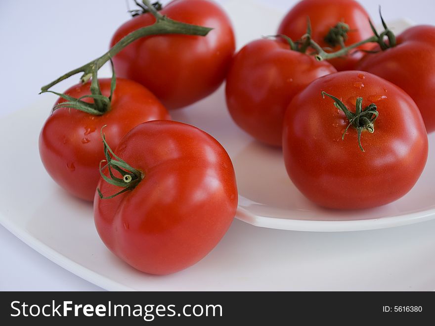 Red tomatoes on the white square dishes
