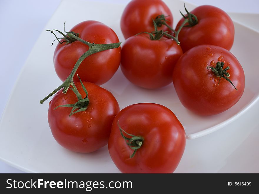 Red tomatoes on the white square dishes