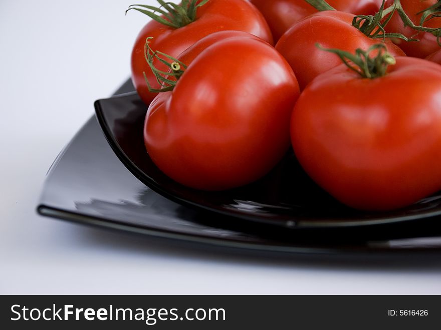 Red tomatoes on the black square dishes