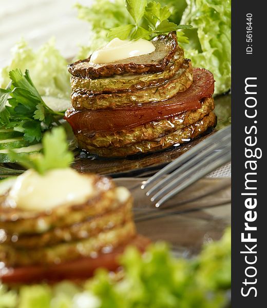 Slices of fried vegetable marrow with salad