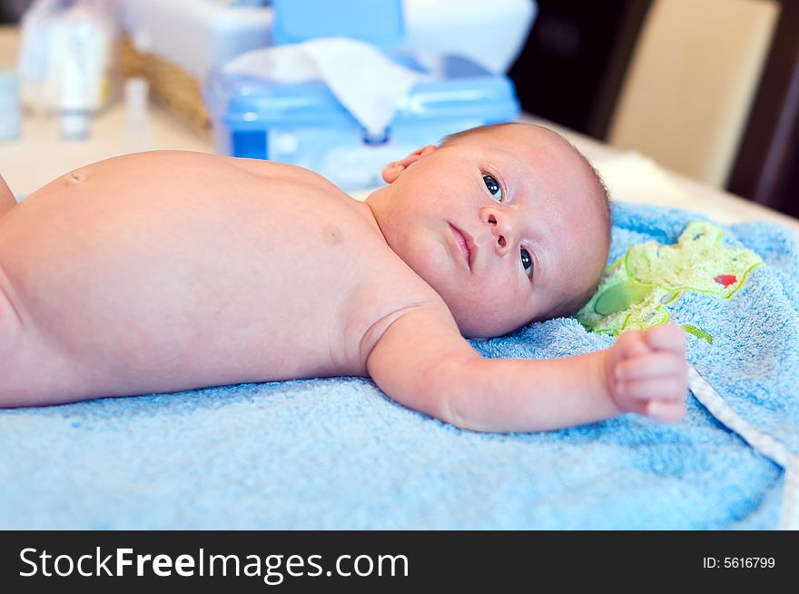 Five weeks thoughtful baby lying on bathing towel. Five weeks thoughtful baby lying on bathing towel