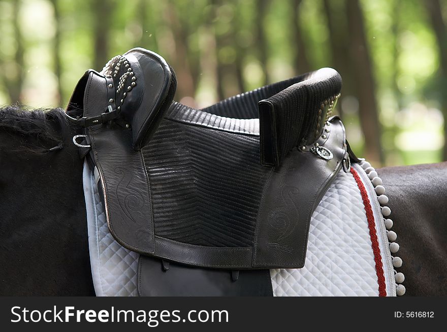 Close up image of an old black leather saddle