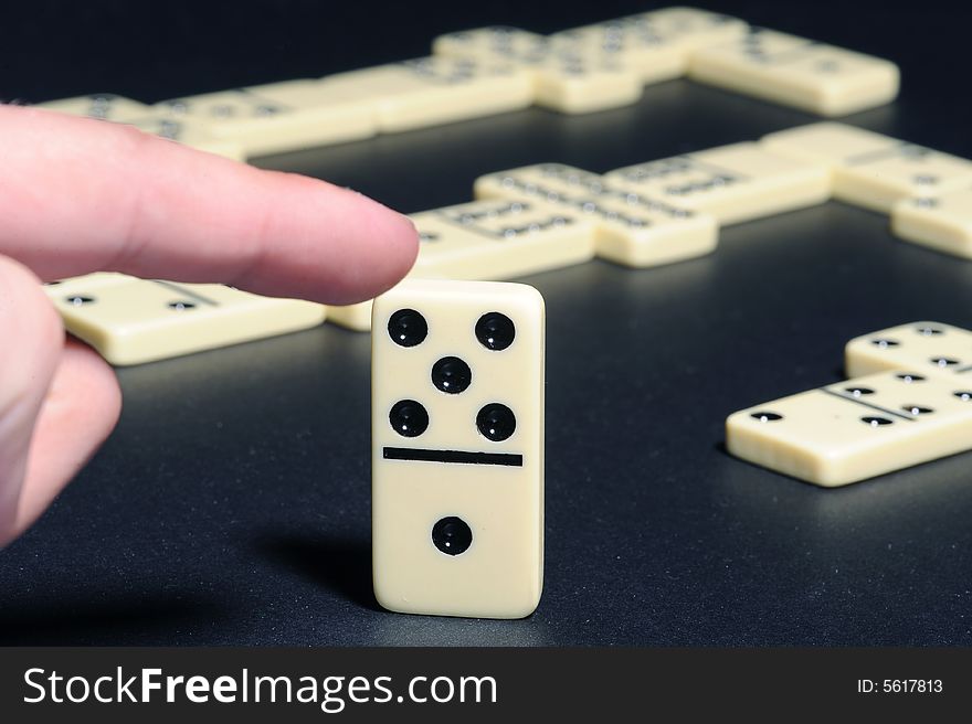 Human Fingers Push A Dominoes.