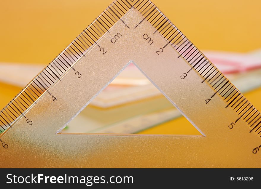 Geometric rulers on top of yellow colored paper