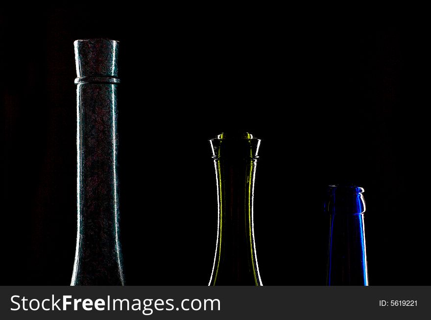 An image of three necks of bottles on black background
