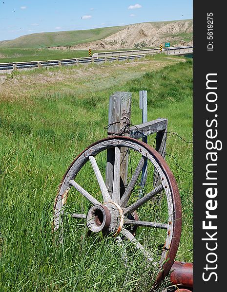 an antique car wheel, rusted out in a farm in southern alberta prairie, canada