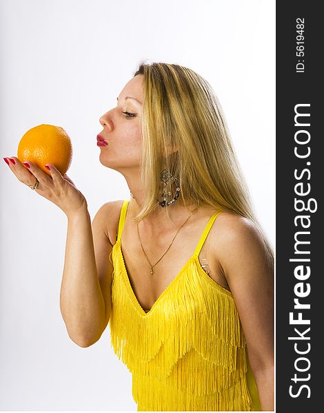 Blonde woman in yellow dress with orange in her hand. Blonde woman in yellow dress with orange in her hand