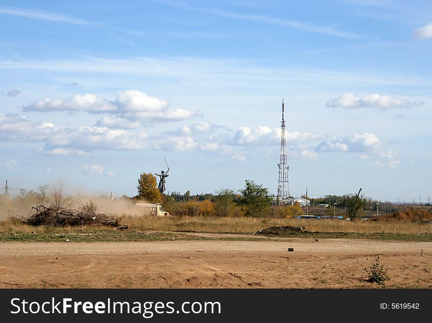 Television antenna and field on background blue sky and clouds
