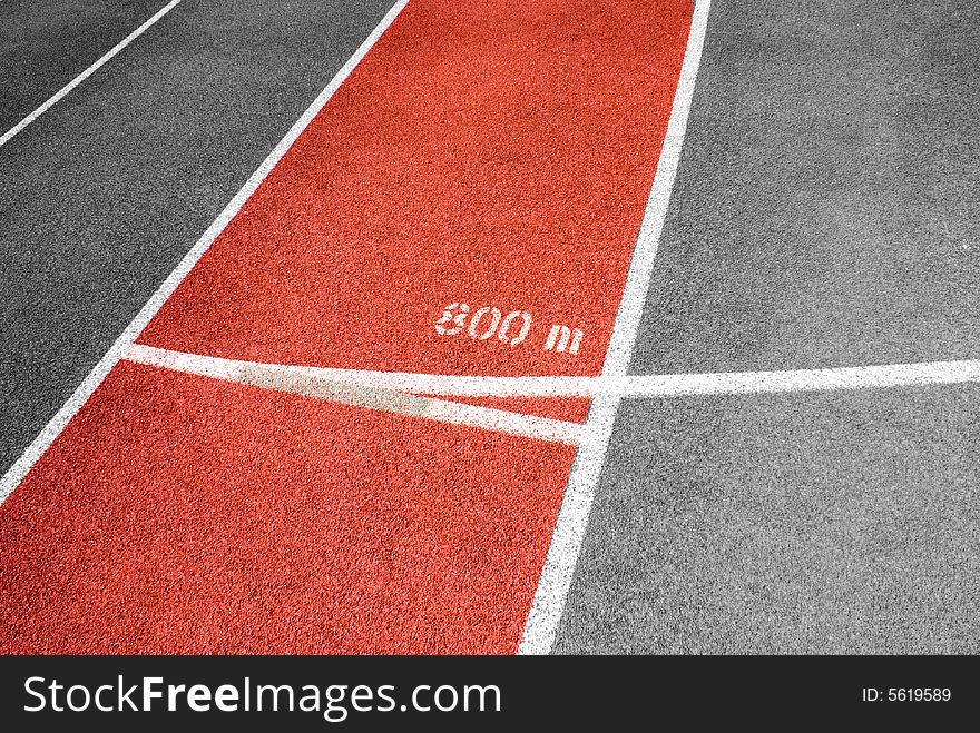 Red plastic raceway separated by numbered white lines in a sunny day