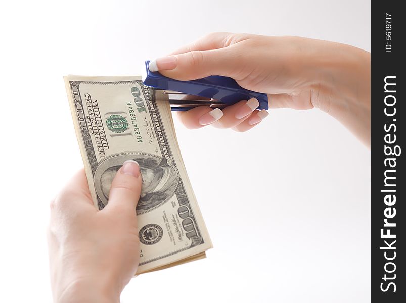 Female hands stapling us dollars, isolated, over white, with clipping path. Female hands stapling us dollars, isolated, over white, with clipping path
