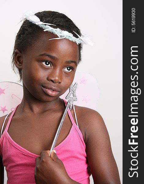 Young girl wearing a pink fairy costume with accessories