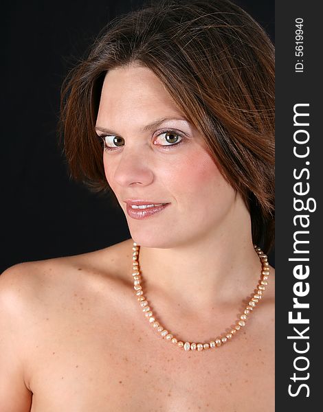 Beautiful young woman with bare shoulders and pearls. Beautiful young woman with bare shoulders and pearls