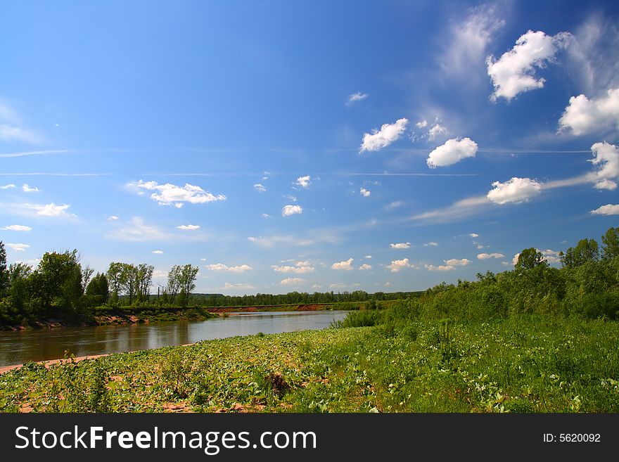 Summer landscape with river under blue sky