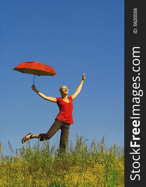 Girl with an umbrella on a meadow