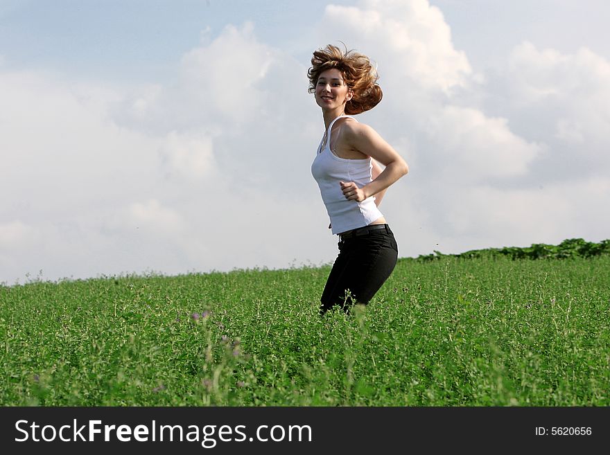 A beautiful girl jumping on the field