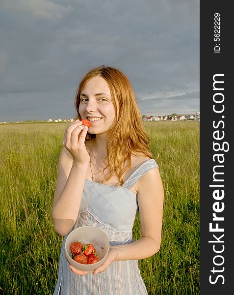 Girl With Strawberry On Meadow