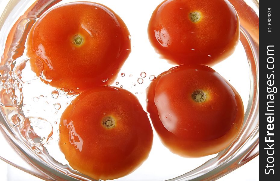 Four fresh tomatoes washing with cold water