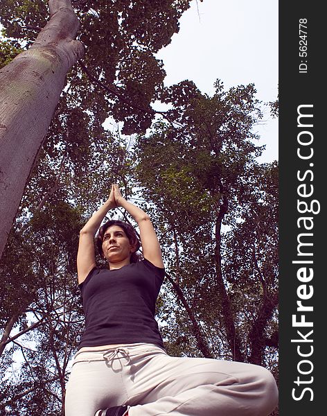 Woman In Yoga Pose In Park - Vertical