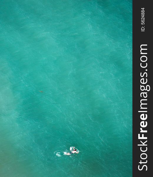 Lonely swimmer on tropical blue water. Lonely swimmer on tropical blue water