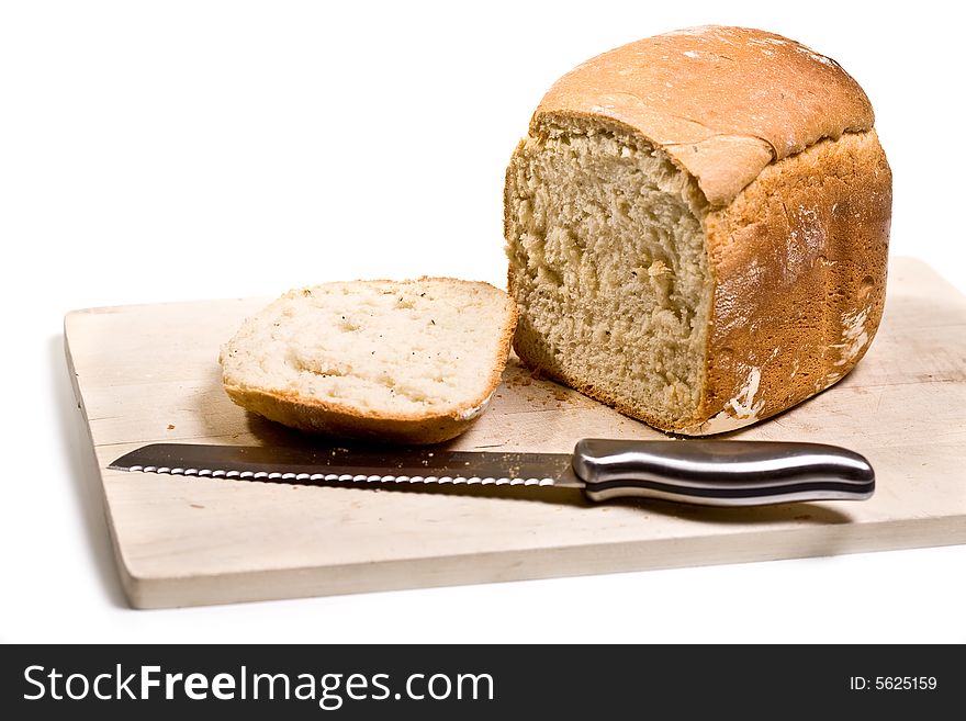 Loaf of homemade white bread on cutting board - isolated on white background