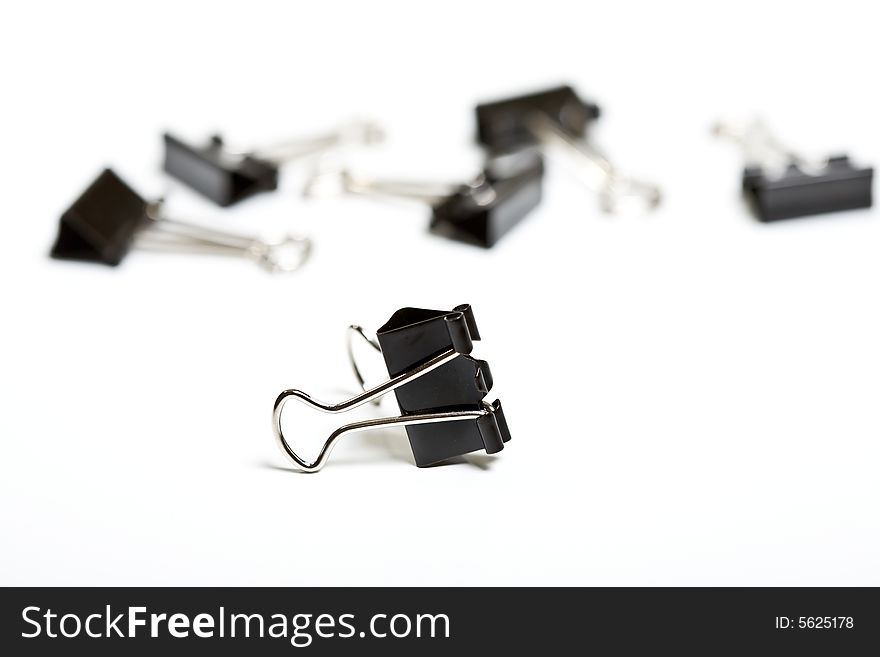 A closeup of black metal binder clip on white background