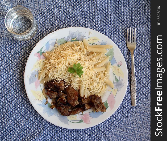 Pork chops with the pasta strewed by parmesan, and cabbage salad and glass of water