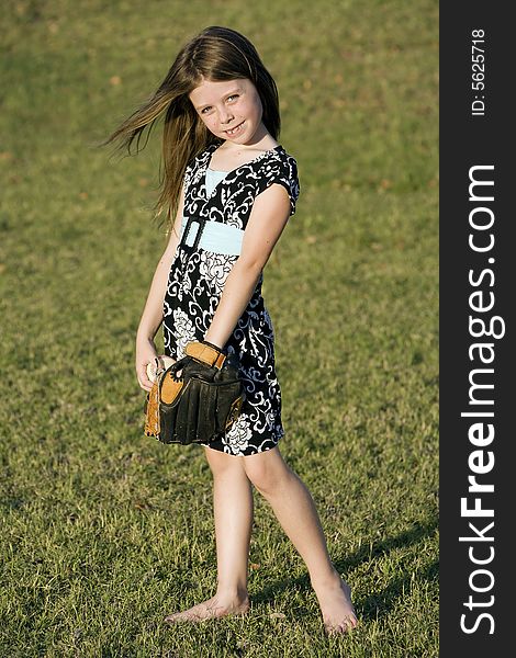 Cute young girl in summer dress with a baseball. Cute young girl in summer dress with a baseball