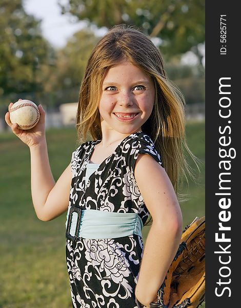 Cute young girl in summer dress with a baseball. Cute young girl in summer dress with a baseball