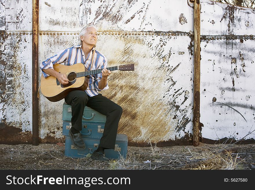 Handsome man playing an old acoustic guitar. Handsome man playing an old acoustic guitar