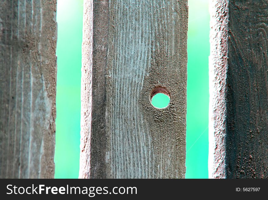 Wooden garden fence with a small hole in one of the elements. Wooden garden fence with a small hole in one of the elements